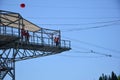 On the tower in the amusement park, a guy and a girl are getting ready to jump on the bungee jumping. Photo from afar Royalty Free Stock Photo