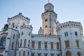 Tower of ancient European castle with clock and windows and battlements on roof for defense Royalty Free Stock Photo