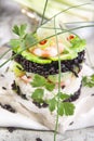 Tower of black and white rice with shrimp and zucchini