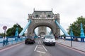 Tower Bridge in central London with people and traffic. Looking straight down the centre of the bridge.