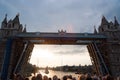 Tower bridge getting opened in London, United Kingdom. People look at bridge over Thames river on grey sky. Architecture