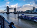 Tower bridge tower of London thames river pier ferry boat city of London winter day warm lights business district uk