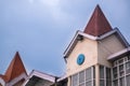 Tower of building with conical roof shot against a blue cloudy s