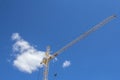 The tower building crane is yellow against the blue sky. Construction equipment Royalty Free Stock Photo