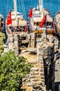 The tower of the castle of St. Peter in Bodrum. Among the tower is a round stone table, and in the background are visible yachts s