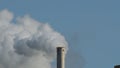 Tower chimney in industrial factory expelling smoke and contamination