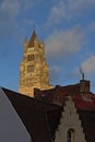 tower of the church of our Lady above the rooftops of medieval houses in  Bruges, Royalty Free Stock Photo