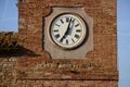 Tower clock with Roman numerals in front of brick wall Royalty Free Stock Photo