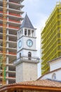 tower clock between two buildings under construction on Skanderberg square in
 capital Tirana in Albania. Royalty Free Stock Photo