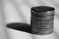 Tower of coins. Hard sunlight and shadows. Side view. Bw photo