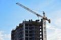 Tower crane in action on blue sky background. Preparing to pour a bucket of concrete into formwork. ÃÂ¡rane lifting cement bucket