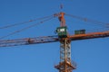Tower crane against blue sky on a construction site for building of multi storage building or another type of structure. Royalty Free Stock Photo