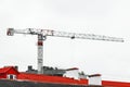 Tower crane against the gray sky builds a new city modern building on the construction site Royalty Free Stock Photo