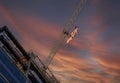 Tower Crane with an American flag waving near a modern office building under construction against a sunset sky Royalty Free Stock Photo