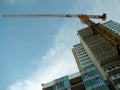 Tower crane attached to concrete building during construction. Royalty Free Stock Photo