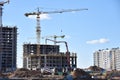 Tower crane and builders in action on blue sky background. Workers during formwork and pouring concrete through a ÃÂoncrete pump