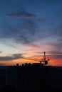 Tower crane and building construction site silhouette at sunrise. Royalty Free Stock Photo