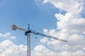 Tower Crane in the clouds and blue sky. The Crane tower in construction site of a high-rise condominium. High cranes on the constr