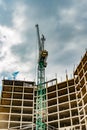 Tower crane at the construction site of a high-rise building, against a background of a terrible sky with clouds. The concept of t Royalty Free Stock Photo