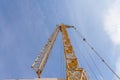 Tower crane at a construction site. Lowered tower crane on sky background Royalty Free Stock Photo