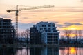 Tower crane and high residential apartment buildings under construction on lake shore. Real estate development Royalty Free Stock Photo