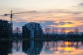 Tower crane and high residential apartment buildings under construction on lake shore. Real estate development Royalty Free Stock Photo