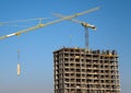 Tower crane lifts the block for building under construction at background blue sky at sunny day. Precast concrete  slab hanging Royalty Free Stock Photo