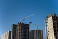 Tower crane lifts the block for building under construction at background blue sky at sunny day. Precast concrete  slab hanging Royalty Free Stock Photo