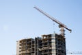 Tower crane lifts the block for building under construction at background blue sky at sunny day. Precast concrete slab hanging Royalty Free Stock Photo