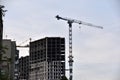 Tower crane near a house under construction in the city during the day Royalty Free Stock Photo