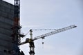 Tower crane near a house under construction in the city during the day Royalty Free Stock Photo