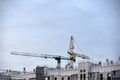 Tower crane near a house under construction in the city during the day Royalty Free Stock Photo