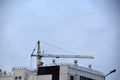 Tower crane near a house under construction in the city during the day Royalty Free Stock Photo