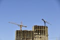 Tower crane near a house under construction in the city during the day Royalty Free Stock Photo