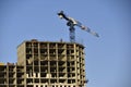 Tower crane near a house under construction in the city during the day Royalty Free Stock Photo