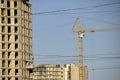 Tower crane near a house under construction in the city during the day Royalty Free Stock Photo