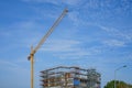 Tower crane over a building under construction. Against the backdrop of a blue sky Royalty Free Stock Photo