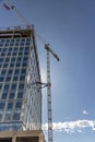 Tower Crane in an urban setting next to a modern glass office building under construction