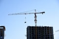 Tower crane working at construction site against blue sky background. Cranes build the high-rise building. New residential Royalty Free Stock Photo