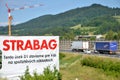 Tower crane working on construction site of slovak D1 highway, billboard of Strabag building company in foreground Royalty Free Stock Photo