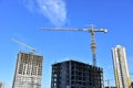 Tower cranes in action during construction residential building on blue sky background. Builder workers during formwork and