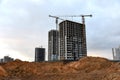 Tower cranes build the high-rise buildings. Crane working at construction site. New residential skyscraper on sunset background. Royalty Free Stock Photo