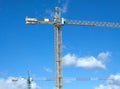 Tower cranes in construction process over blue sky with clouds Royalty Free Stock Photo