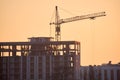 Tower cranes at high residential apartment buildings construction site in evening. Real estate development Royalty Free Stock Photo