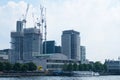 Tower cranes and tall buildings besides the river Thames, London