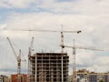 Tower cranes work during the construction of a multi-story building. New apartments for residents and premises for offices. Risky Royalty Free Stock Photo