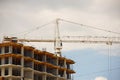 Tower cranes work during the construction of a multi-story building. New apartments for residents and premises for offices. Risky