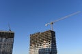 Tower cranes working at construction site against blue sky background. Crane build the high-rise building. New residential Royalty Free Stock Photo