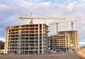 Tower cranes working at construction site against blue sky background. Crane build the high-rise building. New residential Royalty Free Stock Photo