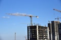 Tower cranes working at construction site on blue sky background Royalty Free Stock Photo